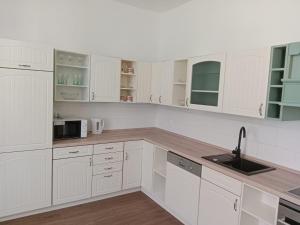 a white kitchen with white cabinets and a sink at Apartmán Netolice in Netolice
