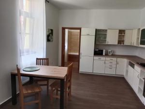 a kitchen with a wooden table and a dining room at Apartmán Netolice in Netolice