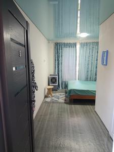 a bedroom with a green bed and a window at Asian Guest House in Bishkek