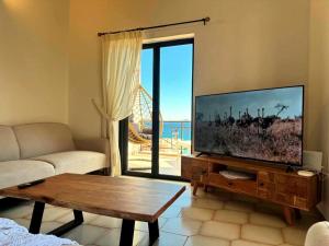 a living room with a large flat screen tv at Kastelia in Yéfira