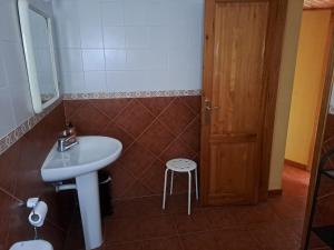 a bathroom with a sink and a wooden door at Casa rural Casa Camilo in Agüero
