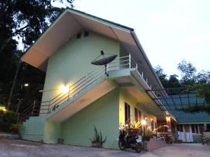 a house with a balcony with a motorcycle parked in front at Pingpong 's house Koh chang in Ko Chang