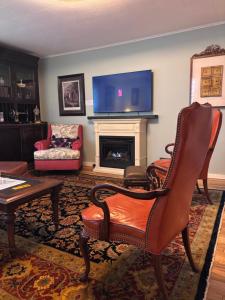 a living room with a fireplace and a tv at Cannon House Retreat in Fayetteville
