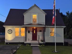 a white house with a flag in front of it at Cannon House Retreat in Fayetteville