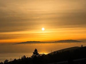 a sunset with the sun setting over the ocean at Nido del Sol in Guía de Isora