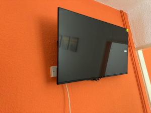 a flat screen tv hanging on an orange wall at Mirage Hotel in Blackpool