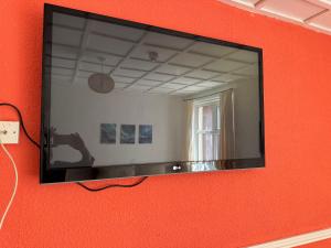 a mirror on a wall with a red wall at Mirage Hotel in Blackpool