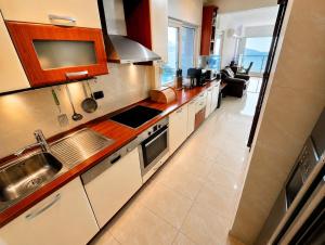 a kitchen with a sink and a stove at Penthouse Bečići Apartament in Bečići