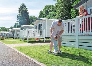a man playing with a little boy with a soccer ball at Heather View Holiday Park in Stanhope