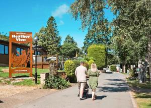 a man and a woman walking down a sidewalk at Heather View Holiday Park in Stanhope
