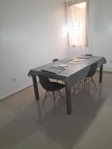 a table with two chairs and a table with papers on it at Résidence habitat nimbo in Bouaké +7 photos