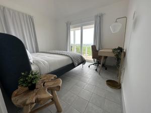 a bedroom with a bed and a desk and a window at The View Villa in Hartswell