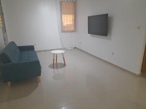 a living room with a blue couch and a table at Résidence habitat nimbo in Bouaké