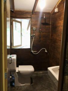a bathroom with a toilet and a window and a tub at Sky Forest in Habarana