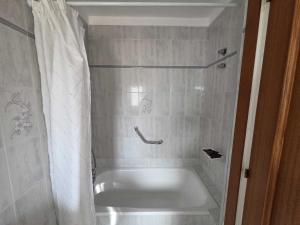 a bath tub with a shower curtain in a bathroom at Can Llança in Llança +25 photos