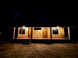 a couple of chairs sitting outside of a building at night at Suraksha Homestay in Malpe