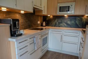 a kitchen with white cabinets and a microwave at Haus Fine in Millstatt