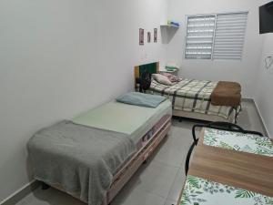 a room with two twin beds and a window at Parque Ecológico - Studio 3 - Térreo in Indaiatuba