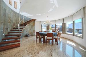 a dining room with a table and chairs and a staircase at Casa La Vinya "Alto Standing" in Palamós