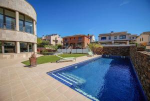 a swimming pool in front of a building at Casa La Vinya "Alto Standing" in Palamós