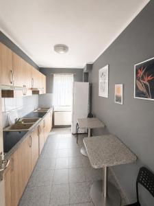 a kitchen with a refrigerator and two tables in it at Villa AGNAT in Gdańsk