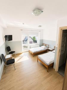 a room with two beds and a chair in it at Villa AGNAT in Gdańsk