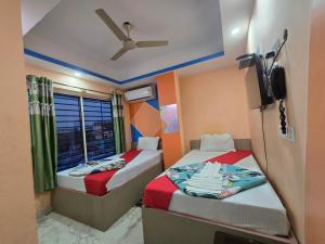 a small room with two beds and a window at Hotel JBL in kolkata