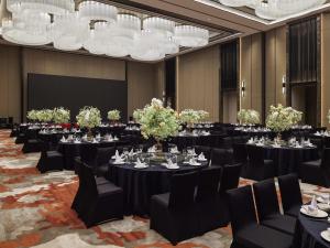 a conference room with tables and chairs and chandeliers at Pullman Suzhou Taicang in Taicang +113 photos