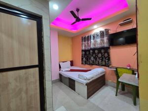 a room with a bed and a ceiling with pink lights at Hotel JBL in kolkata +57 photos