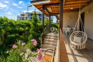 a porch with a swing and a table and chairs at Black Sea Pearl in Krapets