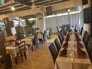 a dining room with tables and chairs and tablesearcher at Au Bon Accueil in Alban