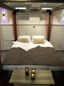 a large bed in a room with a table at Q-Art Hidden Garden City Centre in Novi Sad