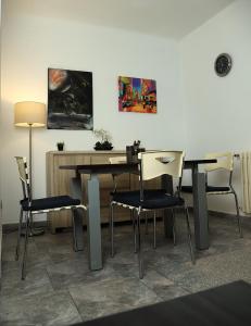 a dining room table with chairs and paintings on the wall at Q-Art Hidden Garden City Centre in Novi Sad