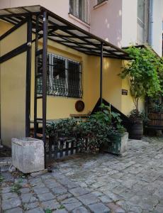 a yellow building with a window and a fence at Q-Art Hidden Garden City Centre in Novi Sad