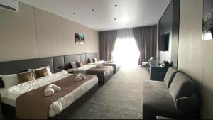 a hotel room with two beds and a couch at Polaris resort in Almaty +5 photos