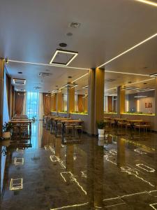 a banquet hall with tables and chairs in a building at Polaris resort in Almaty