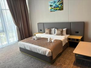 a hotel room with a bed with two towels on it at Polaris resort in Almaty