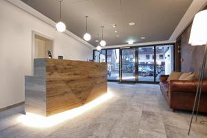 a lobby with a wooden counter and a couch at Hotel Aurelia in Aldingen