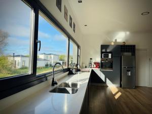 a kitchen with two sinks and a large window at North beach Pinamar in Pinamar
