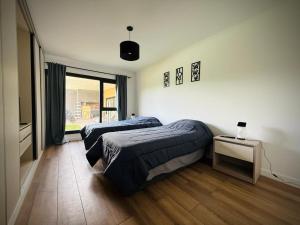 a bedroom with two beds and a television in it at North beach Pinamar in Pinamar