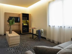 a living room with a couch and a table at ibis Styles Arras Centre in Arras +149 photos