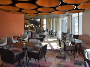 a restaurant with tables and chairs under a ceiling at Novotel Lubumbashi in Lubumbashi