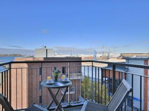 a balcony with a table and chairs on a building at Ohlerich Speicher App_ 27 in Wismar