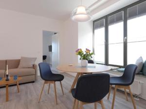 a living room with a table and chairs and a couch at Ohlerich Speicher App_ 14 in Wismar