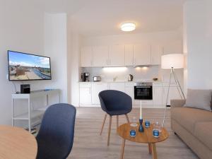 a living room with a couch and a table with chairs at Ohlerich Speicher App_ 14 in Wismar