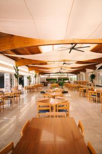 a dining room with wooden tables and chairs at Aparthotel Ciudad Laurel in Cala Millor