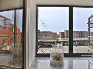 a glass vase sitting on a table in front of a window at Ohlerich Speicher App_ 04 in Wismar