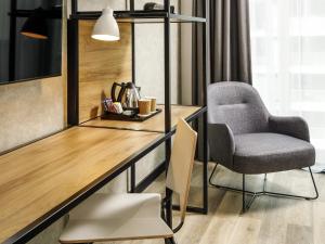 a desk and a chair in a room at ibis London Sutton Point in Sutton