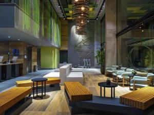a lobby with benches and tables in a building at ibis Styles Porto Alegre Moinhos de Vento in Porto Alegre