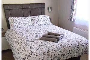 a bedroom with a bed with a black and white comforter at StaticCaravan-6Berth-DogFriendly in Northampton